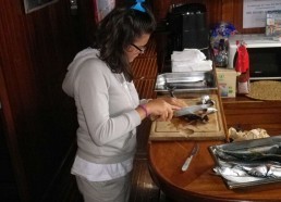 Cecilia prépare les maquereaux pour le repas du midi