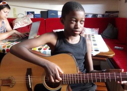 Idrissa s’initiant à la guitare