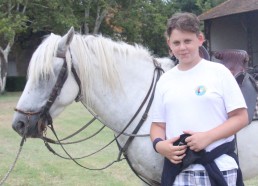 Kylian heureux auprès du cheval blanc