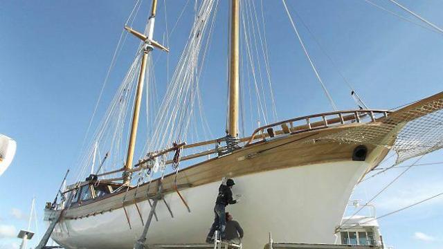 Dans le port de La Turballe, 120 kg d'apprêt et 30 kg de peinture blanche, et le travail de 4 hommes, permettent au « Bora-Bora », sur lequel embarqueront les matelots de la vie, de retrouver sa couleur immaculée., Ouest France 6 mai 2014