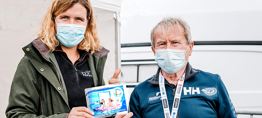 Jean Yves CHAUVE, membre fondateur des Matelots de la Vie et médecin du Vendée Globe, remet le petit mot des Matelots de la Vie à Clarisse CREMER avant son départ pour le Vendée Globe aux Sables d'Olonne.  