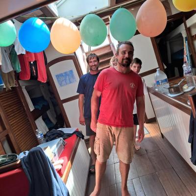 Greg, Julien et Abel sont penchés sur le bateau 