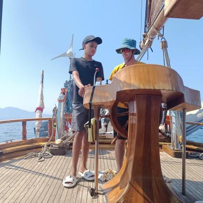 Aaron apprend avec Kévin le marin à barrer le Bora Bora